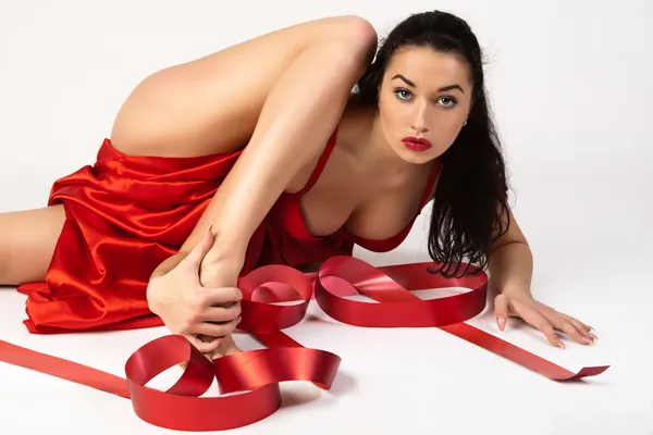 Beautiful young woman is covered with red cloth. — Stock Photo, Image
