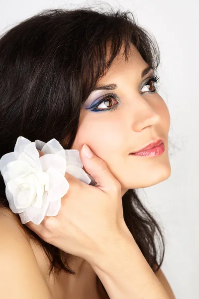 Atraktivní žena portrét s květinou ve vlasech. — Stock fotografie