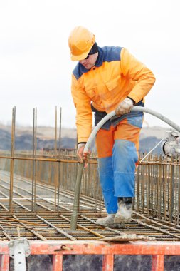 Builder worker pouring concrete into form clipart