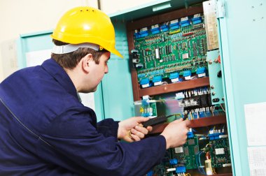 Electrician checking current at power line box clipart