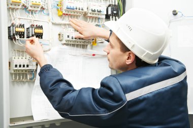 Electrician with drawing at power line box clipart