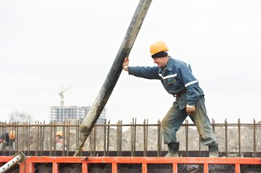 Builder worker pouring concrete into form clipart