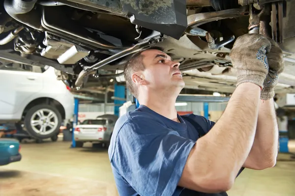 Mécanicien automobile aux travaux de réparation de suspension de voiture — Photo