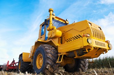 Ploughing tractor at field cultivation work clipart