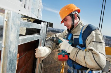 Worker builders at facade tile installation clipart