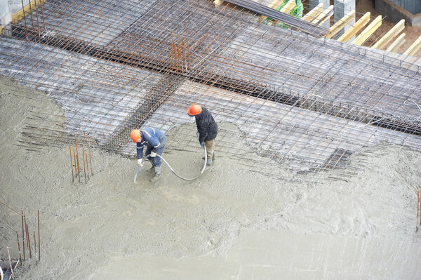 Builder workers at concrete pouring work