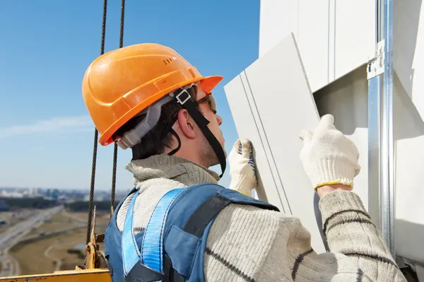 Constructor en la instalación de baldosas de fachada aireada —  Fotos de Stock
