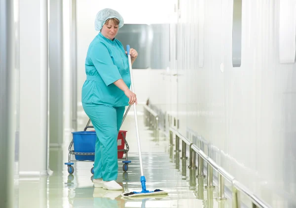 Женщина убирает больничный зал — стоковое фото