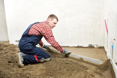 Plasterer concrete worker at floor work clipart