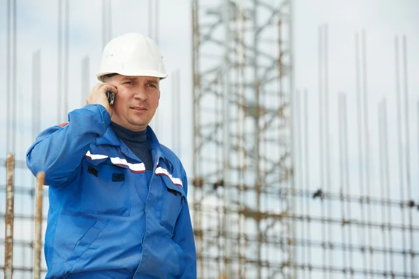 Foreman at construction site with mobile phone — Stock Photo, Image