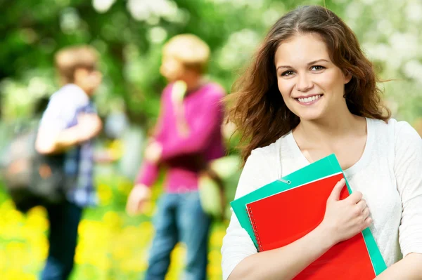 Chica estudiante sonriente al aire libre con libros de trabajo —  Fotos de Stock