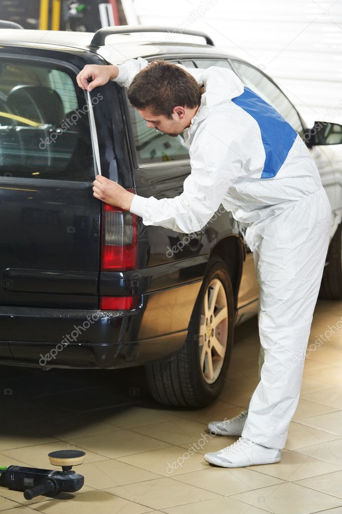 Auto mechanic protecting car before polishing