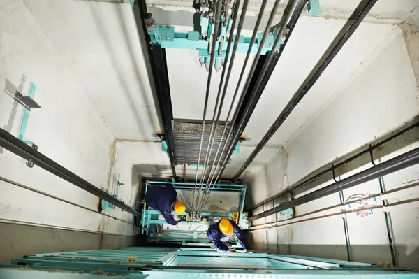 Машинисты регулируют подъемник в лифте — стоковое фото