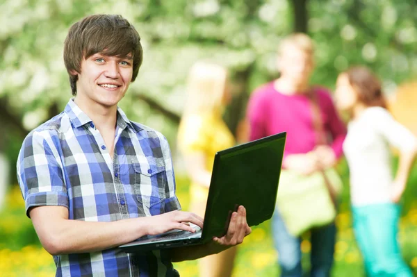 Lachende jonge student jongen met laptop — Stockfoto