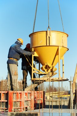 Construction workers pouring concrete in form clipart