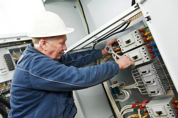 Electricista apriete los tornillos con llave — Foto de Stock