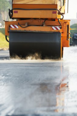 Compactor roller at asphalting work clipart