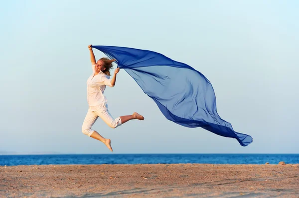 Šťastná žena, skákání na mořské pláži — Stock fotografie