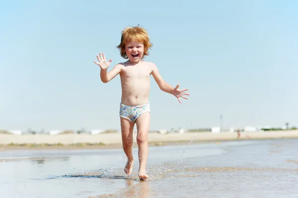 Little girl running on sandy red sea shore — Stock Photo, Image