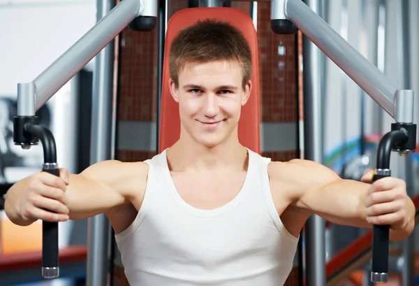 Hombre positivo en la máquina de ejercicios de pecho —  Fotos de Stock