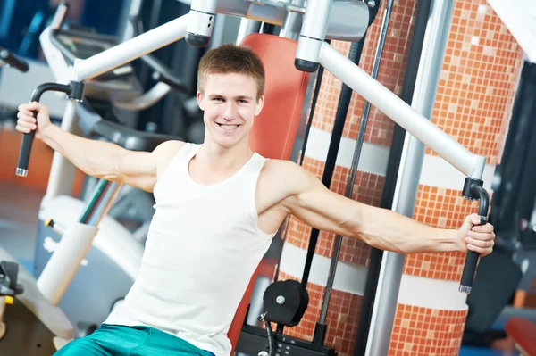 Positive man at chest exercises machine — Stock Photo, Image