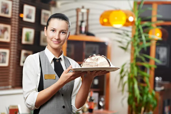 Dziewczyna kelnerka z ciasta na talerzu w restauracji — Zdjęcie stockowe