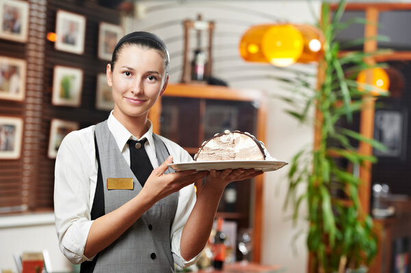 Waitress girl with cake on plate at restaurant