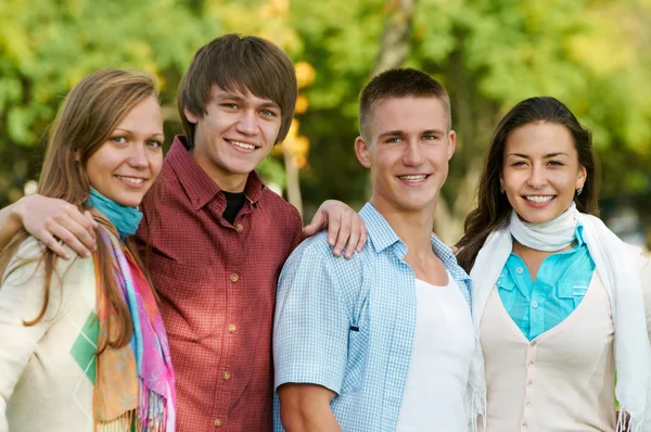Группа улыбающихся молодых студентов на открытом воздухе — стоковое фото