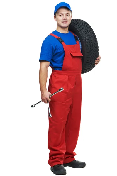 Automobile mechanic with car tire and spanner — Stock Photo, Image