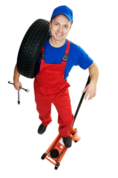 Automobile repairman with tire and lifting jack — Stock Photo, Image