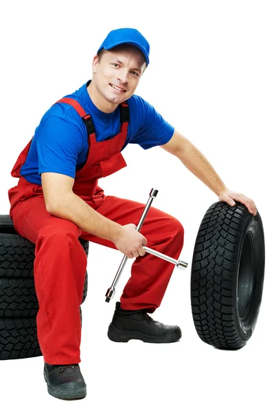 Mecânico de automóveis com pneu de carro e chave inglesa — Fotografia de Stock