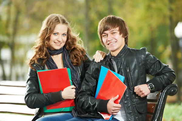 Två leende unga studenter som studerar utomhus — Stockfoto