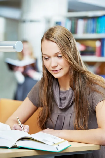 Young student girl working with book in library Stock Picture