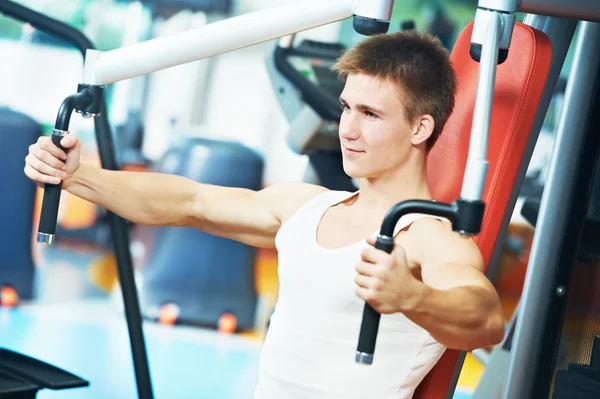 Homem positivo na máquina de exercícios torácicos — Fotografia de Stock