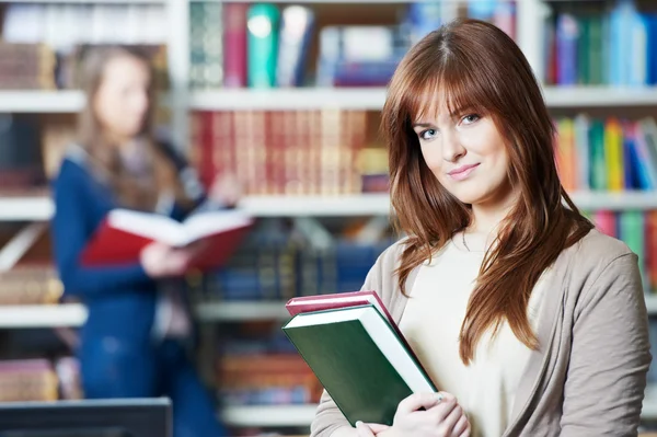 Ung student tjej studie med bok i biblioteket — Stockfoto