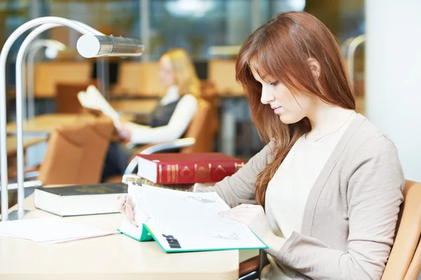 Νεαρός φοιτητής κορίτσι μελέτη με το βιβλίο στη βιβλιοθήκη — Φωτογραφία Αρχείου