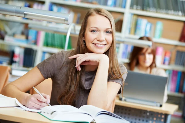 Giovane studentessa che lavora con il libro in biblioteca — Foto Stock