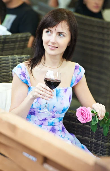 Flicka med vin på café på en dag — Stockfoto
