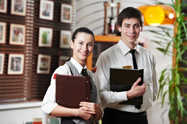 Waitress girl and waiter man in restaurant — Stock Photo, Image