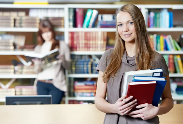 Giovane studentessa studio con libri in biblioteca — Foto Stock