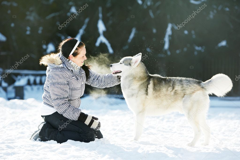 Woman play with siberian husky dog at winter