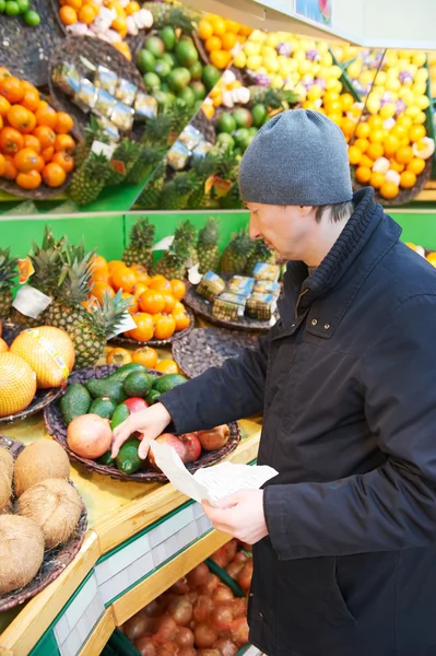 Muž volba zeleninu v supermarketu úložišti — Stock fotografie