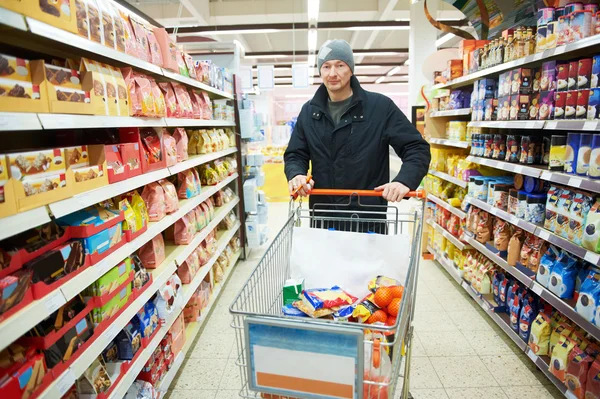 Muž volba zeleninu v supermarketu úložišti — Stock fotografie