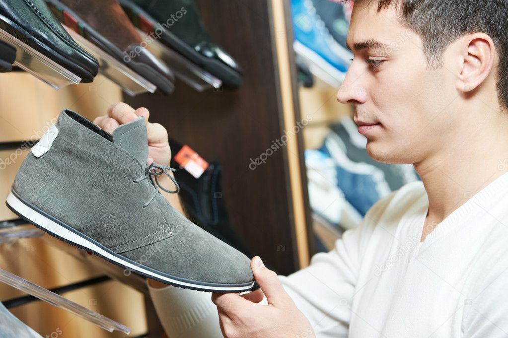 Young man choosing shoe in clothes store