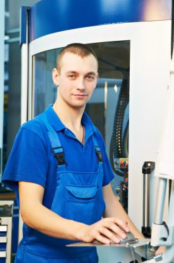 Worker at machine tool in workshop clipart