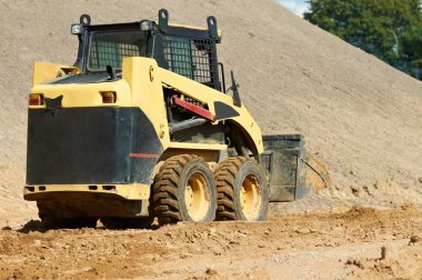 Skid steer loader at earth moving works clipart