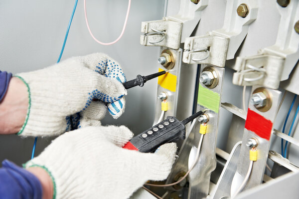 Крупный план Руки электрика измерения напряжения
