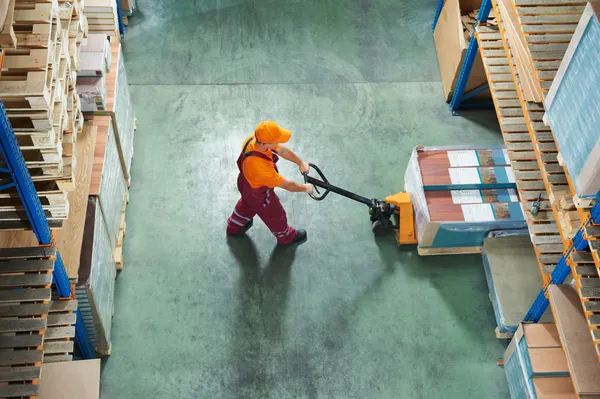 Worker with fork pallet truck — Stock Photo, Image