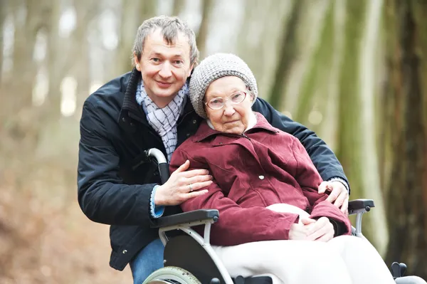 Tekerlekli sandalye ile dikkatli oğlu eski üst düzey kadın — Stok fotoğraf