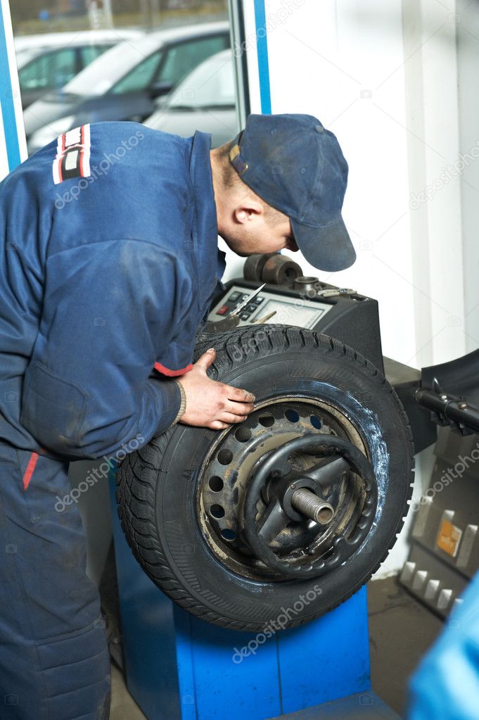 Machanic repairman at tyre balancing adjustment